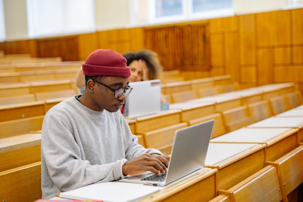 Two graduate students working on laptops in a classroom