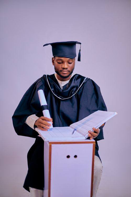 A Master’s student holds his diploma.