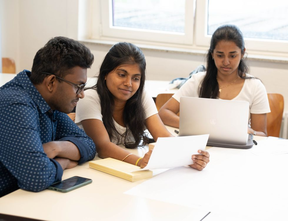 A group of students reviews feedback from a client.