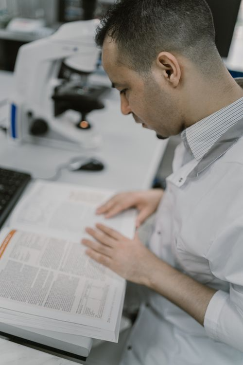 A person studies and reads from a book.