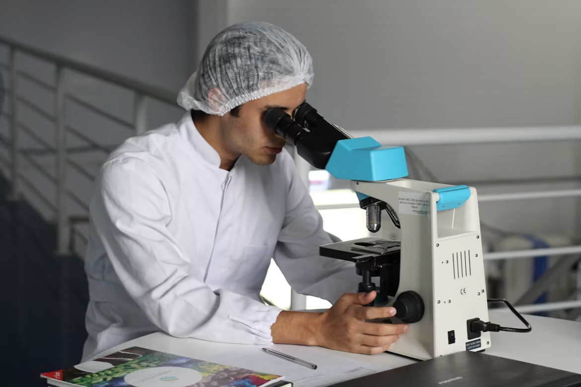 A researcher working on a microscope in a lab.